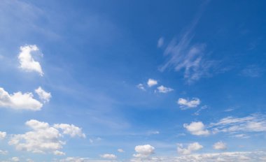 Açık mavi gökyüzü ve bulutların panoramik görüntüsü, küçük bulutlu mavi gökyüzü arkaplanı. Mavi gökyüzünde beyaz kabarık bulutlar. Gökyüzünün ve bulutların büyüleyici güzelliğini gösteren büyüleyici stok fotoğrafı..