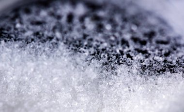 Siyah arkaplanda cam kavanozdaki kristal şekeri kapat.