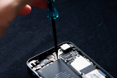 Akıllı telefon hasar gördü ve beyaz arka planda duran akıllı telefonun tamir edilmesi gerekiyor.