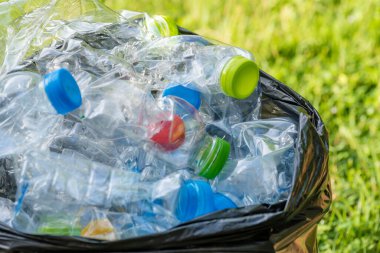 Siyah çöp torbalarındaki plastik şişeler geri dönüşüm için alınmayı bekliyor..