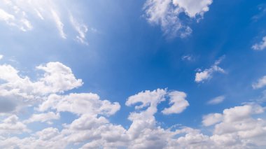 Açık mavi gökyüzü ve bulutların panoramik görüntüsü, küçük bulutlu mavi gökyüzü arkaplanı. Mavi gökyüzünde beyaz kabarık bulutlar. Gökyüzünün ve bulutların büyüleyici güzelliğini gösteren büyüleyici stok fotoğrafı..