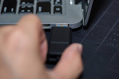 Elle USB bellek ekleme bilgisayarı bir dizüstü bilgisayara bağlandı. El bilgisayara takılı Hardware Cüzdanı yerleştirme.