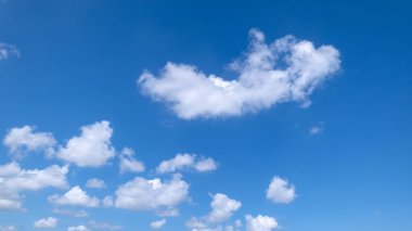 Açık mavi arkaplan, arka planda bulutlar, küçük bulutlu mavi gökyüzü arkaplanı. Mavi gökyüzünde beyaz kabarık bulutlar. Gökyüzünün ve bulutların büyüleyici güzelliğini gösteren büyüleyici stok fotoğrafı..