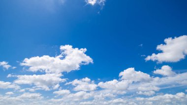 Açık mavi arkaplan, arka planda bulutlar, küçük bulutlu mavi gökyüzü arkaplanı. Mavi gökyüzünde beyaz kabarık bulutlar. 