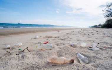 Kirli deniz kumlu kıyı, çevresel kirlilik, okyanustaki plastik su şişeleri kirliliği 