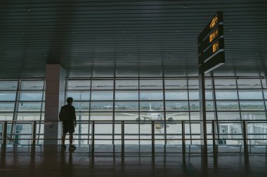 Seyahat, yaz gezisi için havaalanı kapısında bekleyen sırt çantalı turistler. Seyahat. Havaalanı arka planında yaz uçuşu..