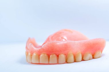 Beyaz arkaplanda eski takma diş..