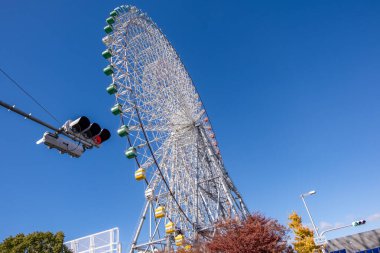 Osaka Akvaryumu Kaiyukan Osaka, Japonya 'daki eğlence parkında mavi gökyüzünün arka planında dönme dolap..
