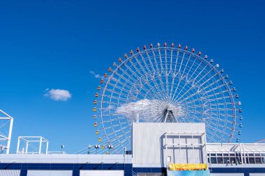 Osaka Akvaryumu Kaiyukan Osaka, Japonya 'daki eğlence parkında mavi gökyüzünün arka planında dönme dolap..