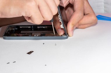 Belgili tanımlık smartphone zarar ve tamirci eller tarafından izole üzerinde beyaz arka plan ayakta hangi araçları akıllı telefon tamir gerek yapıldı..