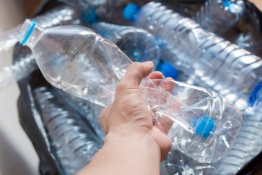 Siyah çöp torbalarındaki plastik şişeler geri dönüşüm için alınmayı bekliyor..