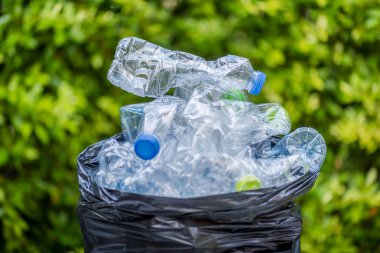 Siyah çöp torbalarındaki plastik şişeler geri dönüşüm için alınmayı bekliyor..