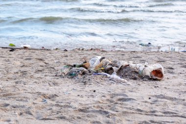 Kirli deniz kumlu kıyı, çevresel kirlilik, okyanustaki plastik su şişeleri kirliliği (Deniz enkazı)
