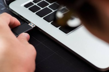 Elle taşınan bellek belleği bir bilgisayar portuna takılıyor. El bilgisayara takılı Hardware Cüzdanı takılıyor..