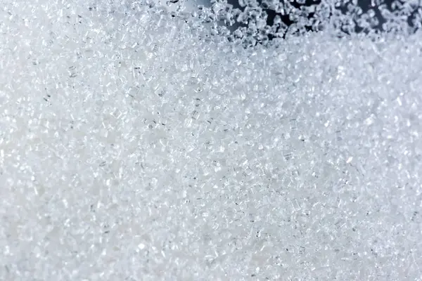 Siyah arkaplanda cam kavanozdaki kristal şekeri kapat.