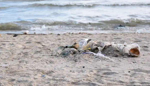 Kirli deniz kumlu kıyı, çevresel kirlilik, okyanustaki plastik su şişeleri kirliliği (Deniz enkazı)