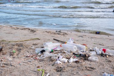 Kirli deniz kumlu kıyı, çevresel kirlilik, okyanustaki plastik su şişeleri kirliliği (Deniz enkazı)