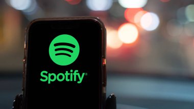 İstanbul, Türkiye - 20 Şubat 2024: Arabadaki akıllı telefondan yapılan bir uygulama. Spotify, akıllı telefonlar ve bilgisayarlar için bir müzik yayınlama servisidir..