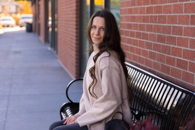 Yalnız bir kadın bankta oturuyor.