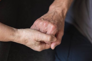 Senoir çifti sarılıp dans ediyorlar.
