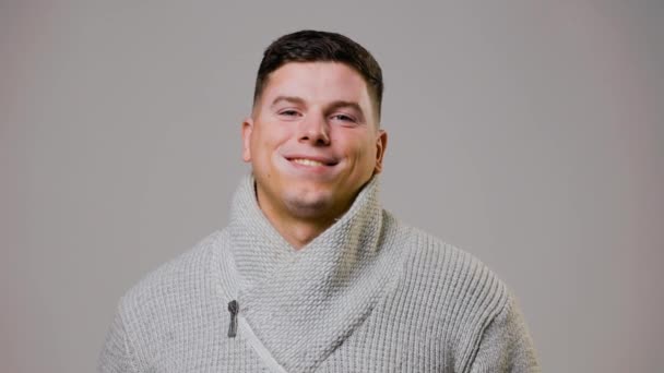 Portret Młodego Mężczyzny Modny Sweter Wygląda Szczęśliwy Przed Kamerą Szarymi — Wideo stockowe