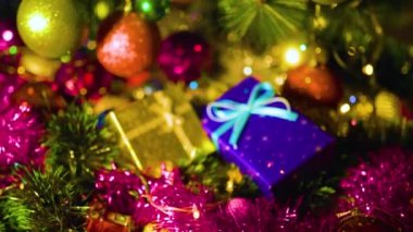 İki hediye kutusu mavi ve sarı yanında kırmızı Noel toplarını sim ile asıyor. Yeni yıl süslerinin, oyuncakların ve hediyelerin güzel parlak renkleri. Seçilene odaklan.