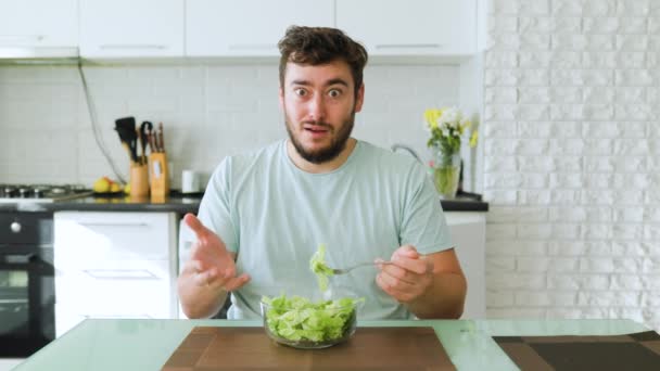 Kamera Önüne Bakan Bir Genç Adam Elinde Vejetaryen Yiyeceklerle Mutfakta — Stok video