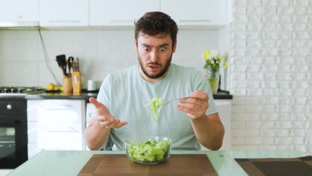 Étonnement Jeune Homme Regarde Une Fourchette Avec Une Salade Main — Video