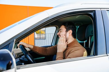  Sakallı sürücü endişeli, direksiyonun arkasındaki aracın içinde diş ağrısı var. Yüzünde eli olan iyi bir adam tahriş edilmiş diş ağrısı, ağzında ağrıdan muzdarip olan ve elini bastıran adam. 