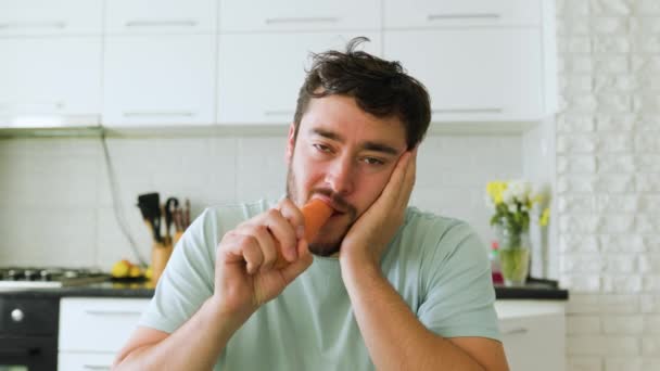 Вид Спереди Молодого Человека Кусающего Сырую Морковку Свирепым Несчастным Выражением — стоковое видео