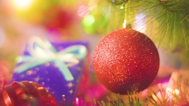ガーランドの青いギフトボックスの輝きを背景に赤いボールを閉じます 休日の雰囲気 新年のクリスマス 選択的焦点 — ストック動画