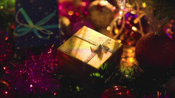 Поверхности Новогодней Мишуры Игрушки Коробка Подарком Золотой Лук Светом Гирлянд — стоковое видео