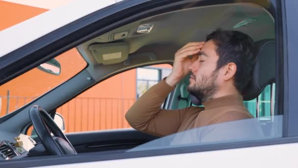 Młody Mężczyzna Siedzi Samochodzie Trzymając Rękę Głowie Boli Kierowca Kierownicą — Wideo stockowe
