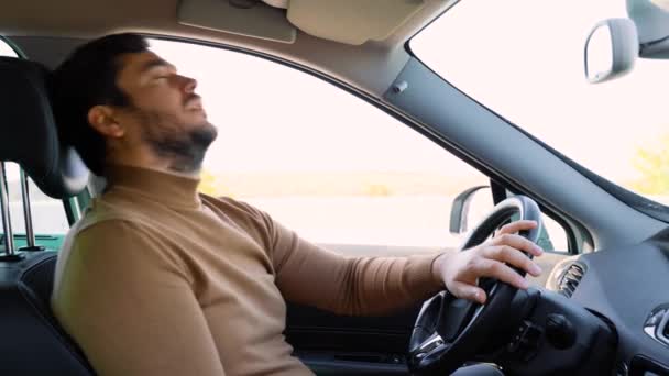 車の若いドライバーは ホイールでは ステアリングホイールの手で 頭が横に眠る 道路上であまりにも多くの時間が疲労につながる 残業はできない — ストック動画