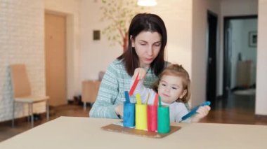 Genç anne, Montessori metoduna göre kızıyla nişanlıdır. Erken gelişim kavramı. Küçük bir çocuk yararlı oyunlar oynamaktan hoşlanır..