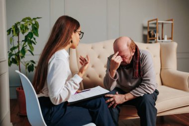 Psikoloji, depresyon, insanlar. Erkekler psikoloğa danışmanlık yapıyor, kadınlar resmi giyinip evde yaşlı bir adamı ziyaret ediyor. İhtiyarlarla konuşan destek işçisi. yaşlılar rehabilitasyonu,