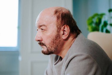 Düşünceli yaşlı adam üzgün, düşünceli melankolik. Kafasına sıkılmış, yaşlı, olgun bir adam koltukta oturuyor. Depresyonda, psikolojik sorunları var. Evde tek başına..