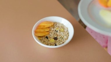 Yulaf lapası ve meyveli en üst tabakta, tanınmayan kadın eli meyve koyuyor. Sağlıklı yemek, sağlıklı kahvaltı..