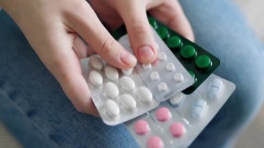 Unrecognizable sick person holds in his hands many blisters with pills close up. Pharmaceuticals are well developed. Human pills for all occasions.