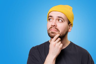The portrait a man with a distrusting expression, as if hes uncertain about something, in a studio shot, providing ample copy space.