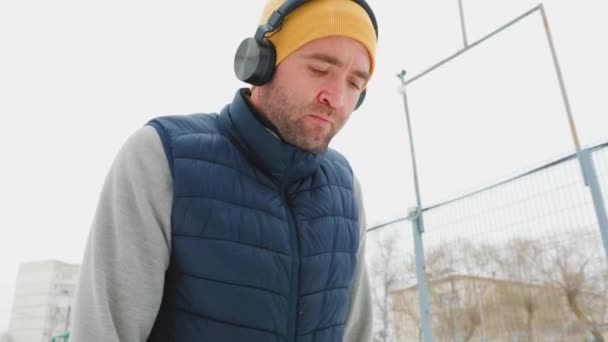Σκληρό Χειμερινό Τρέξιμο Ένας Νεαρός Άνδρας Ακουστικά Φαίνεται Κουρασμένος Γέρνει — Αρχείο Βίντεο