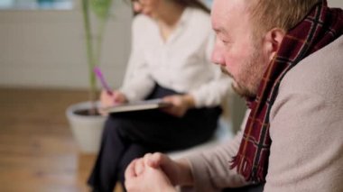 An older adult receives assistance and guidance from a compassionate woman psychiatrist in the privacy of her indoor living room. Living Room Consultation with Female Psychologist