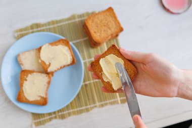 A product shot of butter being spread on a piece of bread, emphasizing the importance of healthy eating habits.