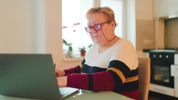 Пожилая Женщина Усердно Работает Над Своим Ноутбуком Носит Очки Проходит — стоковое видео