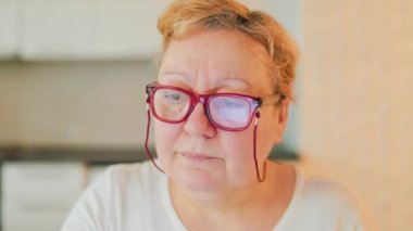 This stock photo features a close-up of a senior womans head, capturing her authentic beauty and charm. She is wearing eyeglasses and looking , of at-home shopping experiences for real people.
