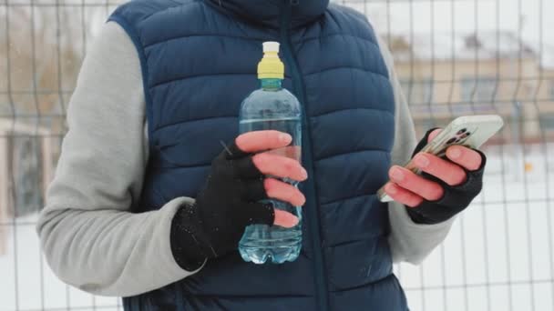 Close View Two Gloved Male Hands Water Bottle Smartphone Winter — Vídeos de Stock