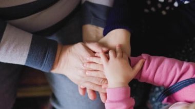 These hands, belonging to a grandparent and grandchild, are the perfect representation of the special connection between different generations, captured in a beautiful close-up photo.