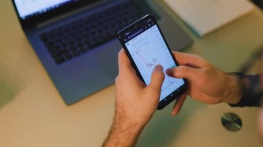 A close-up photo of a brokers hands on a laptop keyboard at home in the nighttime, as they analyze market trends and manage complex financial portfolios.