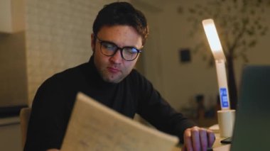 Bringing Education Home A Student Guy Embraces E-Learning at Night A young man, hard at work on his laptop for his e-learning studies, committed to his education as he studies from home