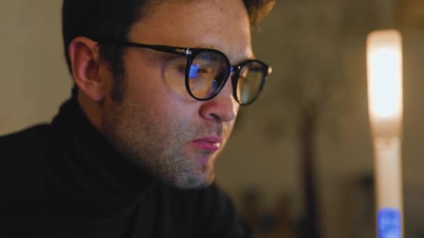 Young Man Eyeglasses Types His Laptop Home Gentle Glow Lamp — Vídeos de Stock